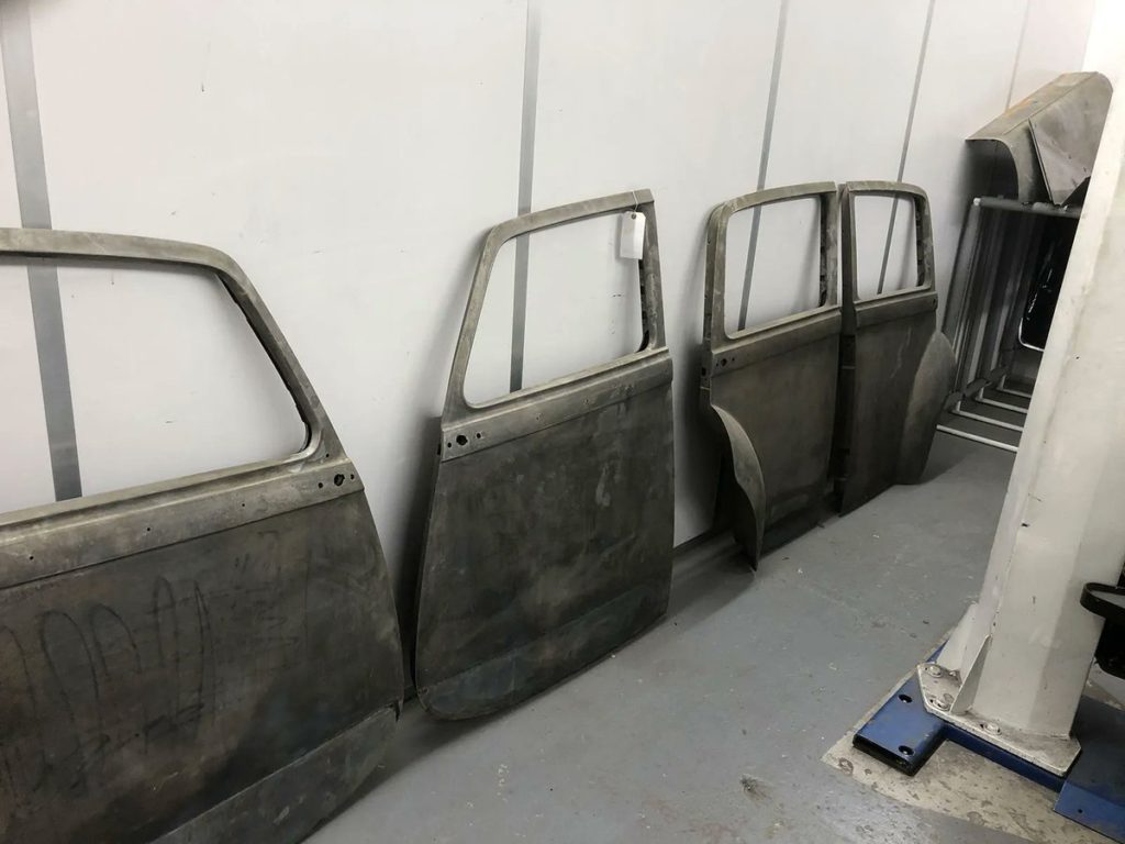 All four Bentley R Type doors looking bare after being chemically stripped.
